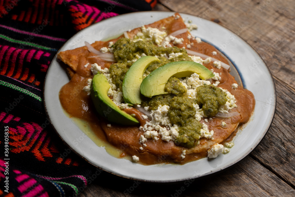 Mexican enfrijoladas with green sauce on wooden background Mexican enfrijoladas with green sauce on wooden background