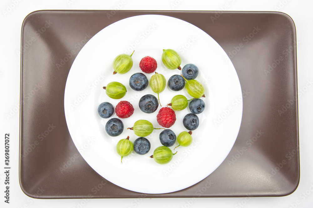 Assorted fresh different berries on a white plate. useful vitamin healthy food fruit. healthy vegetable breakfast Assorted fresh different berries on a white plate. useful vitamin healthy food fruit. healthy vegetable breakfast