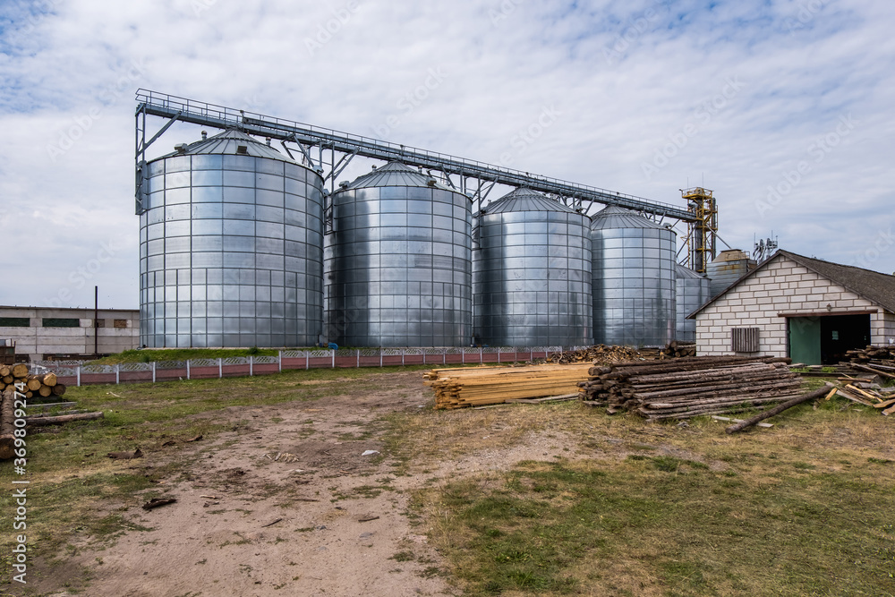 Modern Granary elevator. Silver silos on agro-processing and manufacturing plant for processing drying cleaning and storage of agricultural products, flour, cereals and grain. Modern Granary elevator. Silver silos on agro-processing and manufacturing plant for processing drying cleaning and storage of agricultural products, flour, cereals and grain.