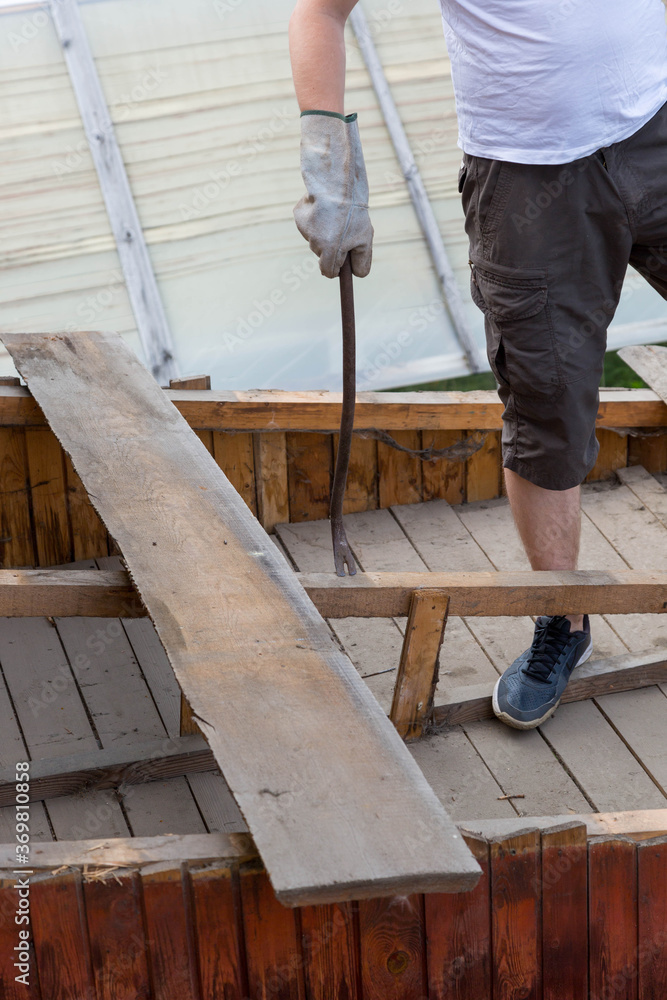 dismantling the roof. The worker removes old boards dismantling the roof. The worker removes old boards
