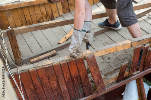 Wallpaper Mural The man knocks an old rotten wooden plank with a hammer Torontodigital.ca