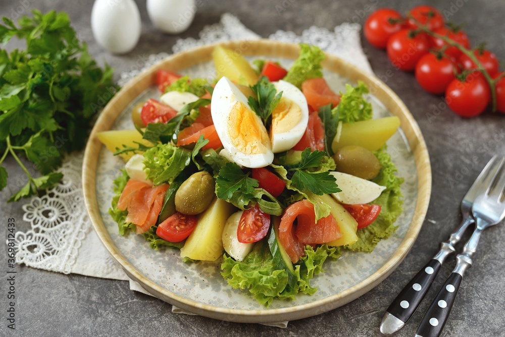 Salad with smoked salmon, lettuce, cherry tomatoes, olives, eggs and potatoes. Salad with smoked salmon, lettuce, cherry tomatoes, olives, eggs and potatoes.