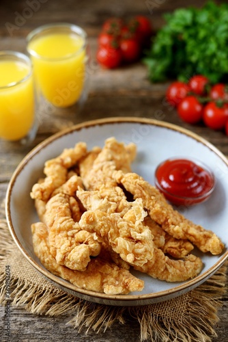 Homemade chicken strips with tomato sauce.