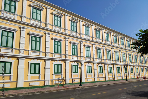 Yellow building with green windows in sunny day