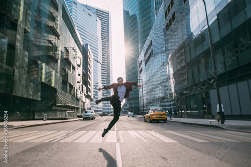 A man jumps over a pedestrian crossing in the business center of the city