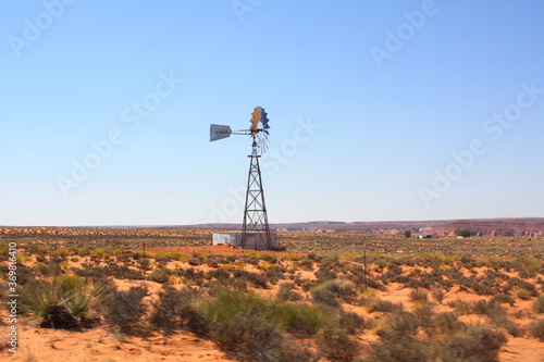 Old Farm Windmill wind turbine for Pumping Water with Spinning Blades at Sunset in New Mexico, USA