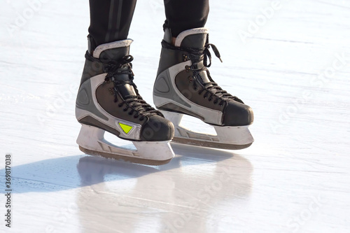 Legs of a man skating on an ice rink. Hobbies and sports.