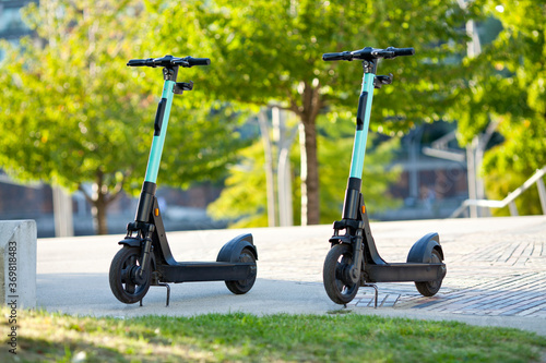 two new electric scooter parking in the city by sunlight