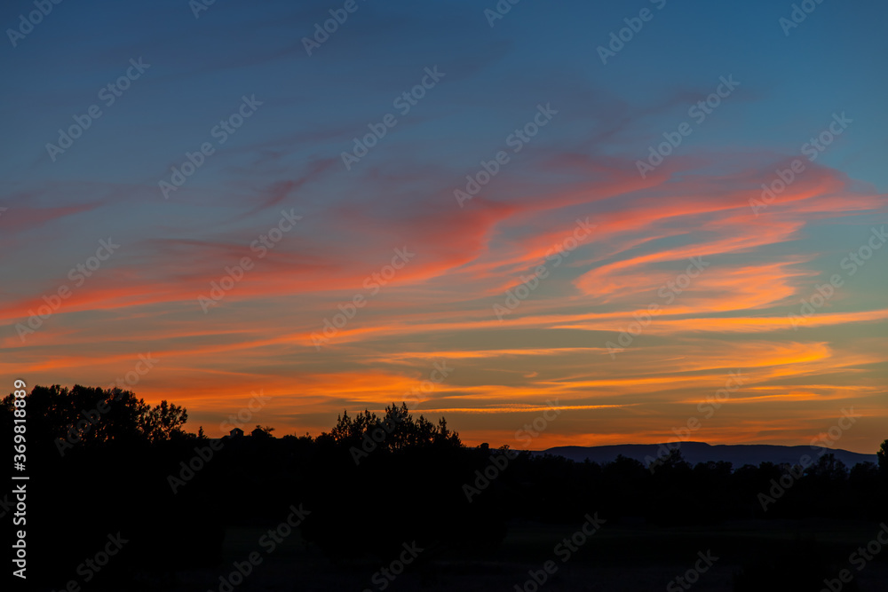 Beautiful sunset with orange clouds in a blue hour sky