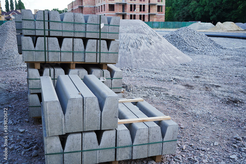 Photos Concrete curbs on wooden pallets stand on the street during street repair
