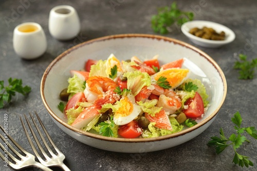Salad with crab meat, shrimp, parmesan, capers, cherry tomatoes and lettuce. Healthly food.