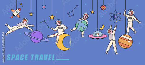 Several planets are adorned like mobiles, and astronauts are playing happily in them. flat design style minimal vector illustration.