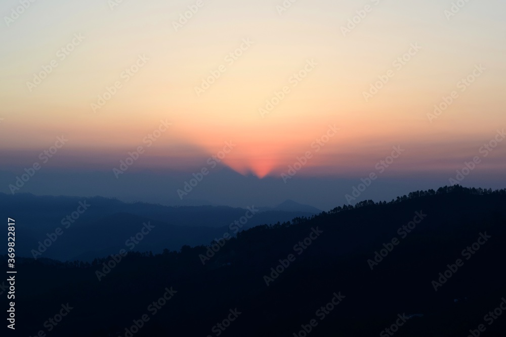 Kausani, Uttarakhand, India, Sunrise in the mountains with sun rays peeping between the Himalayan peaks