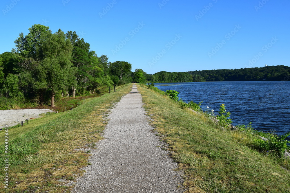 Barton dam, Ann Arbor. Summer landscape with a long riverside walkway beside Huron river