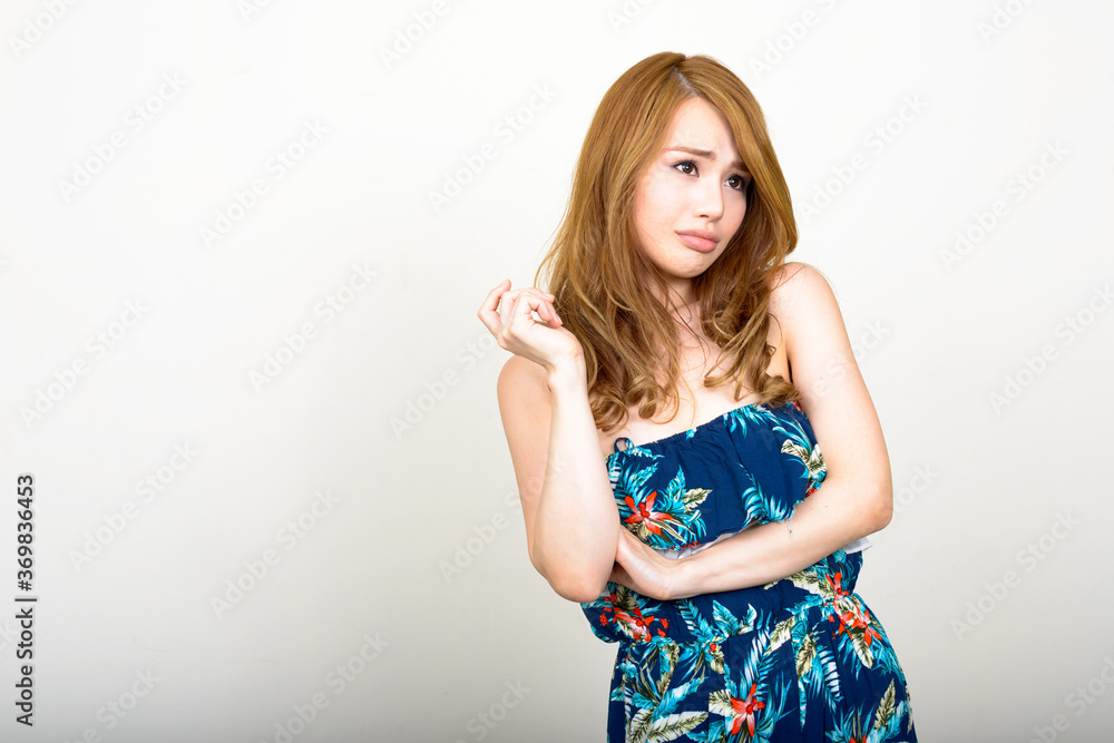 Portrait of young beautiful Asian woman against white background Portrait of young beautiful Asian woman against white background