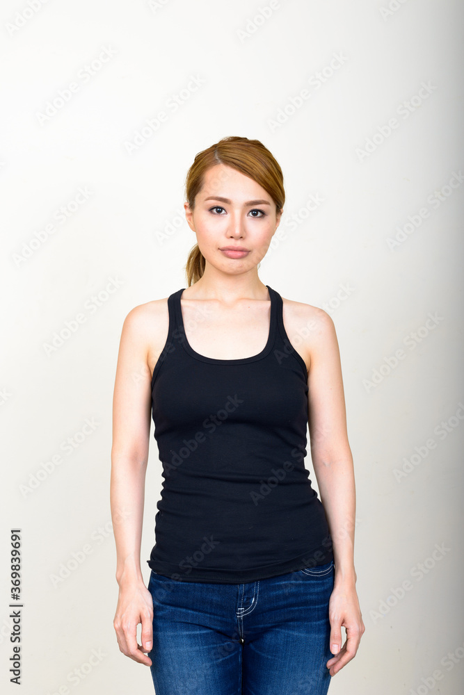 Portrait of young beautiful Asian woman against white background Portrait of young beautiful Asian woman against white background