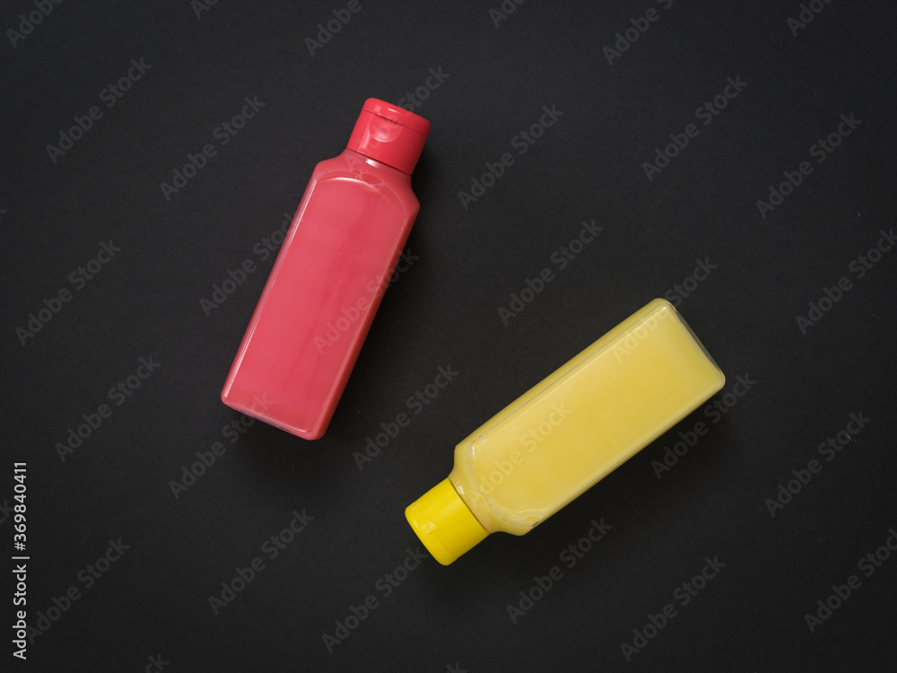 Two plastic bottles with soap solution on a black background. Two plastic bottles with soap solution on a black background.