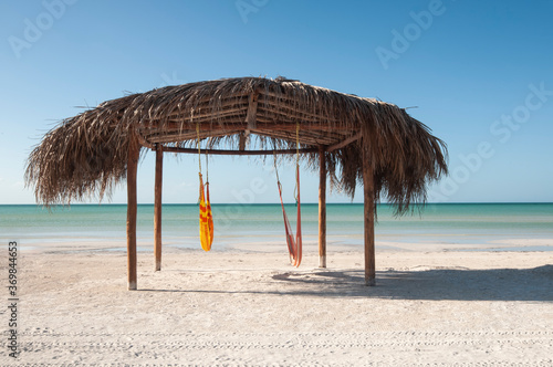 Fototapeta Naklejka Na Ścianę i Meble -  Natural and tropical hut on the beach Caribbean Ocean Front, desert beach whit hammock on a beach in Holbox Island, Mexico
