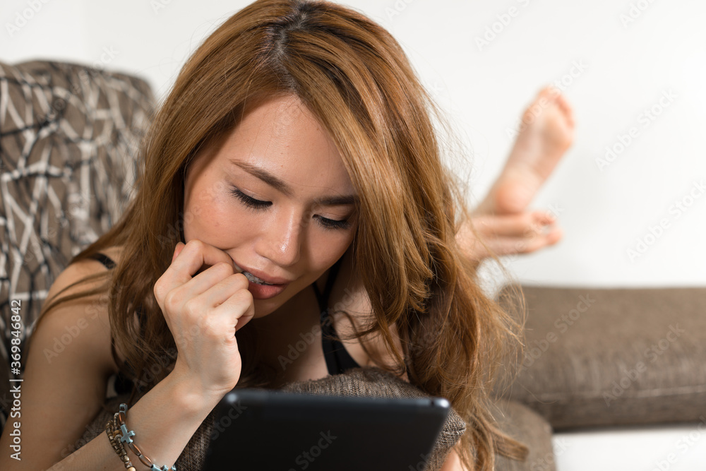 Young beautiful Asian woman in the living room at home Young beautiful Asian woman in the living room at home