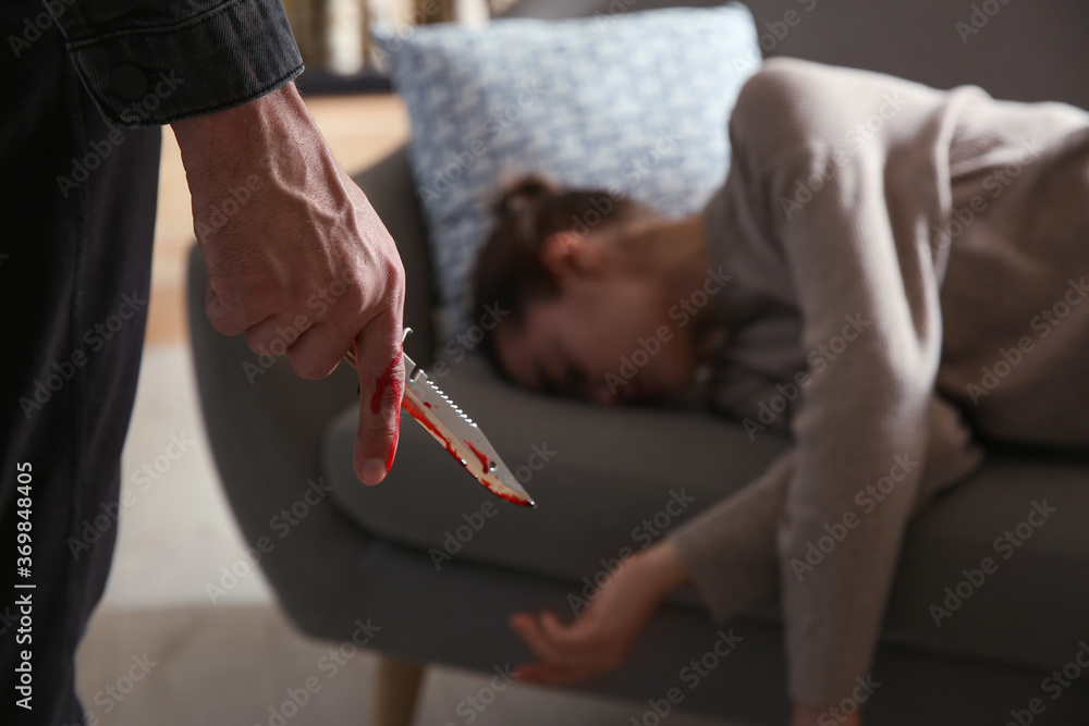 Φωτογραφία Man with bloody knife and his victim on couch indoors, closeup