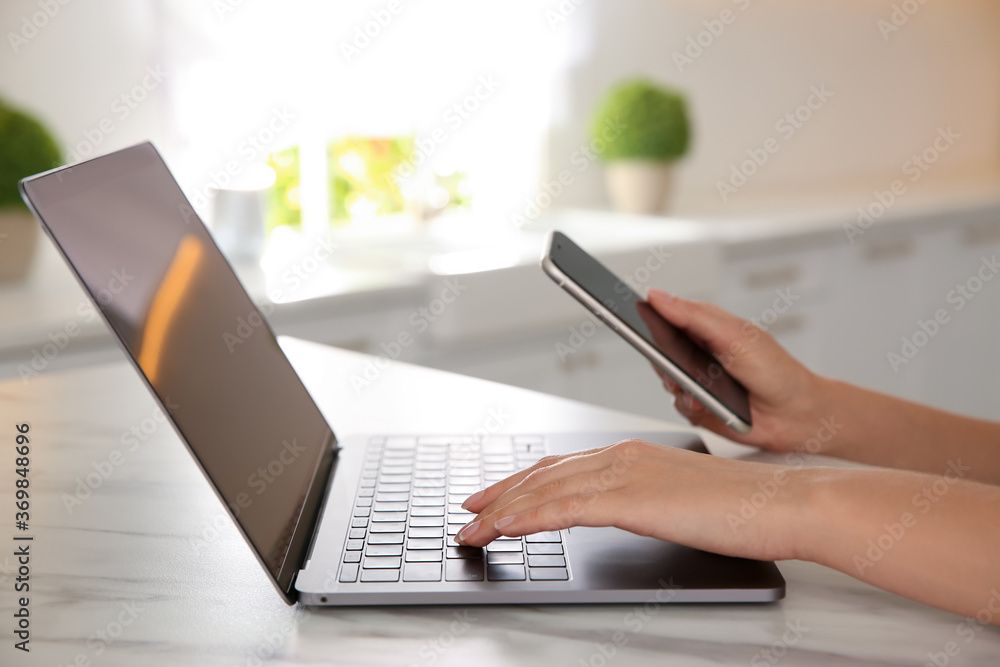 Woman working with modern laptop at marble table, closeup Woman working with modern laptop at marble table, closeup