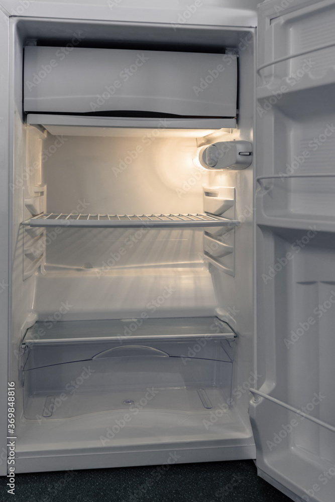 Empty shelves of opened new white fridge Empty shelves of opened new white fridge