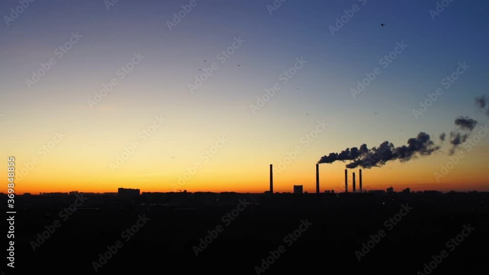 factories smoke or steam into the atmosphere at sunset. concept of environmental pollution factories smoke or steam into the atmosphere at sunset. concept of environmental pollution