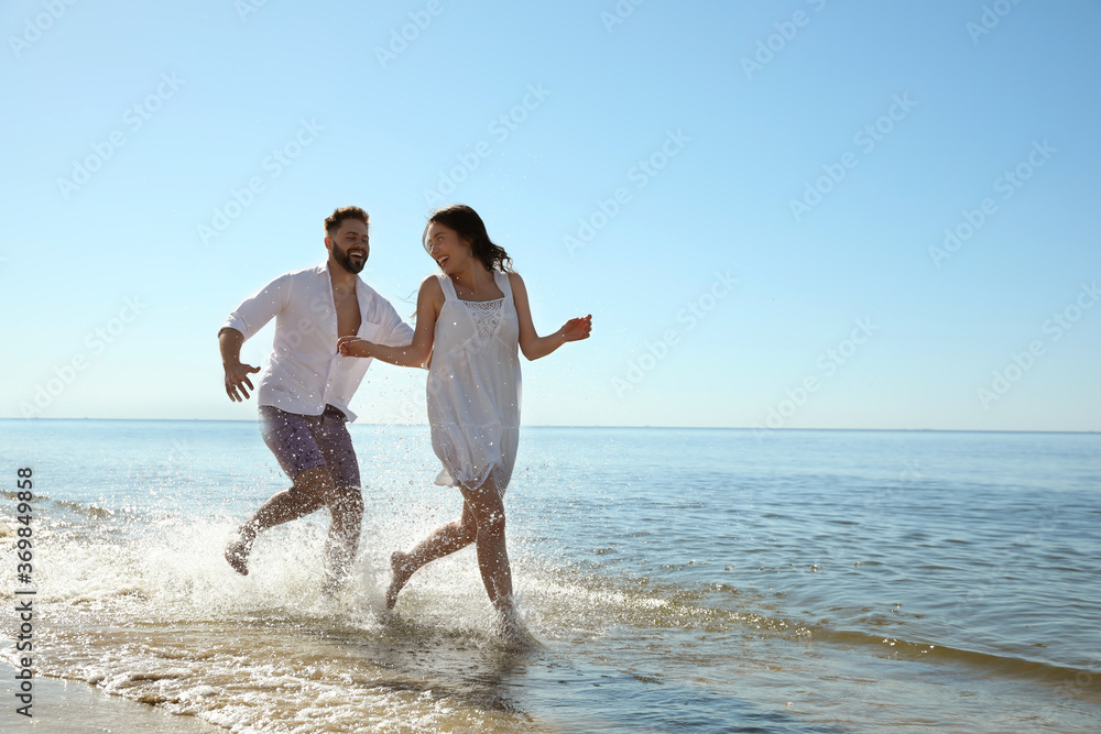 Happy young couple having fun at beach. Honeymoon trip