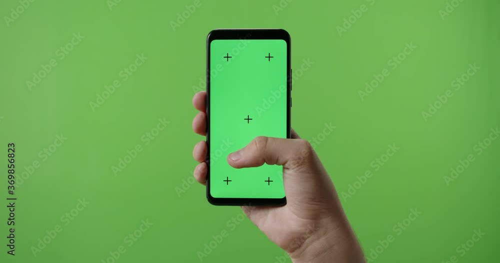 Close up of man's hand holding a smart phone with vertical green mock ...