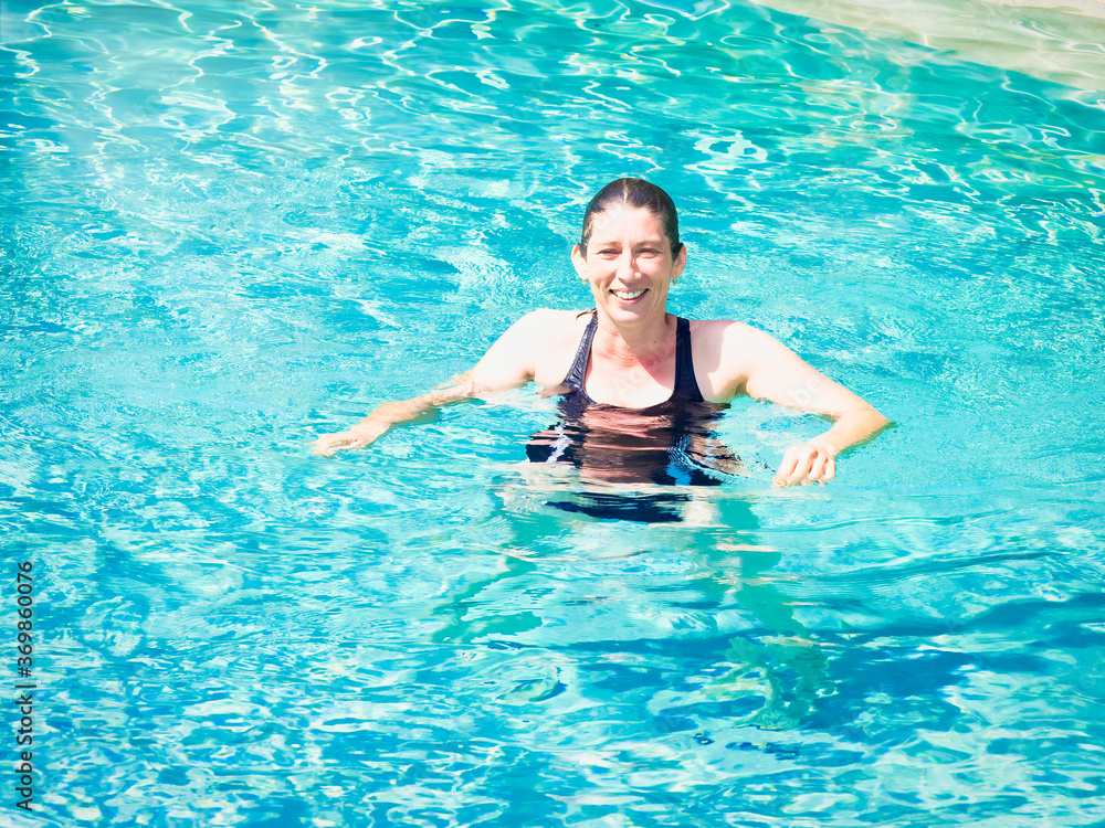 Cheerful senior woman relaxing in swimming-pool Cheerful senior woman relaxing in swimming-pool