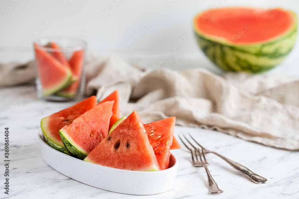 A bowl of watermelon slices with forks on the table. A bowl of watermelon slices with forks on the table.