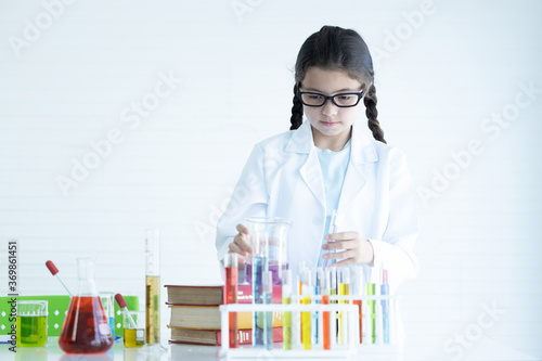 Kid in lab coat learning chemistry in school laboratory, Kid scientist studying science, experimenting with chemicals, Young scientist making experiments laboratory, Child and science, Education.