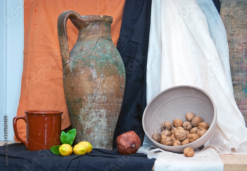 Still life with old jug, lemon, pomegranate and walnuts