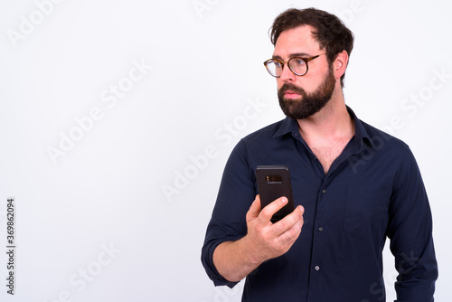Portrait of handsome bearded businessman using phone