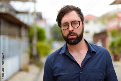 Portrait of handsome bearded businessman with eyeglasses outdoors
