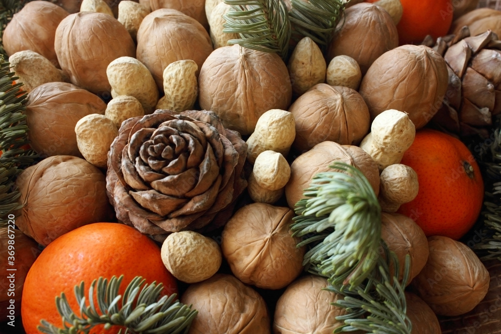 Gift Christmas bouquet. Pine cones, oranges, peanuts, walnuts, spruce branch in a beautiful package. Electoral focus. Christmas and New Year is theme. Holiday theme. Background. Food. View from top.