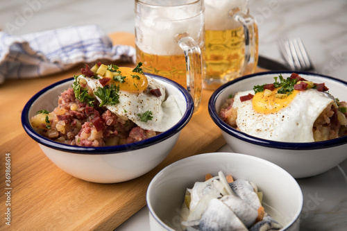 Norddeutscher Hamburger Labskaus mit Rindfleisch Corned Beef, Rote Beete, Kartoffeln, Saure Gurken, Spiegelei, Rollmops und Bier auf Marmor photo