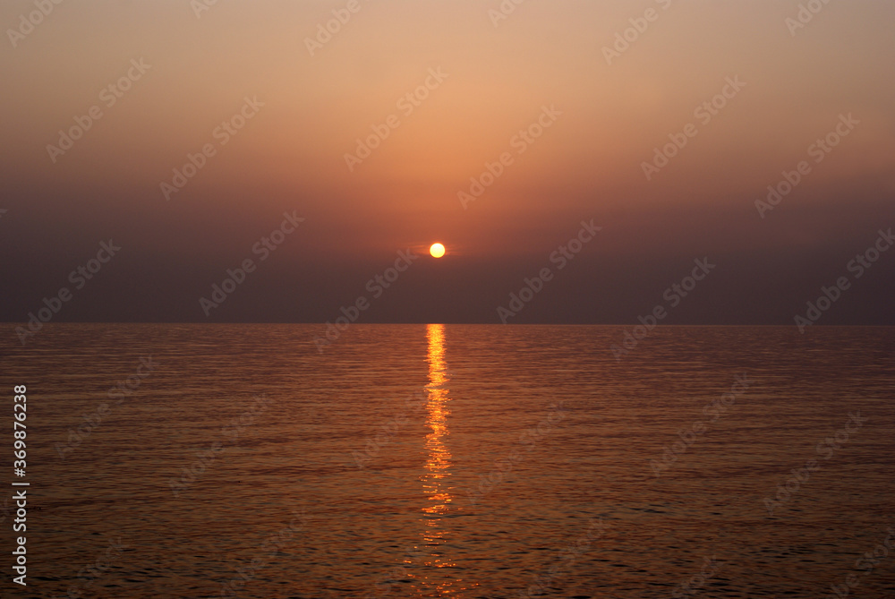 Beautiful dawn over the sea. Sunny path on the water. Light wave and swell on the surface of the water Beautiful dawn over the sea. Sunny path on the water. Light wave and swell on the surface of the water