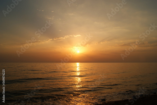 Beautiful dawn over the sea. Sunny path on the water. Light wave and swell on the surface of the water © Olga