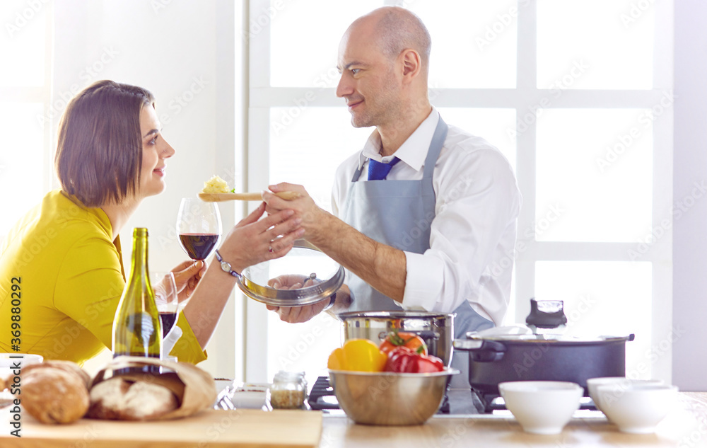 Smiling young couple cooking food in the kitchen Smiling young couple cooking food in the kitchen