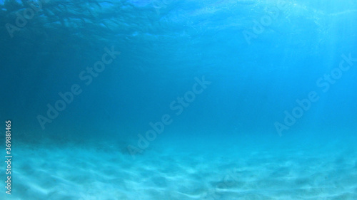 Underwater background of blue sea water and ocean floor 