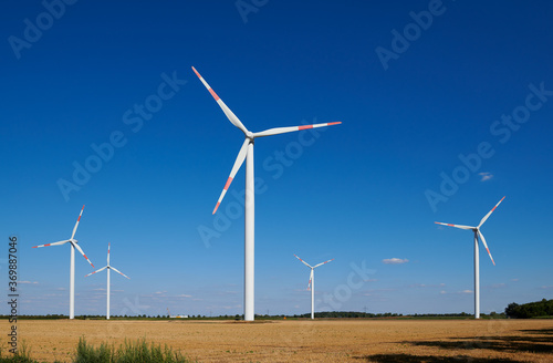 Wind energy / four wind turbines and stubble field