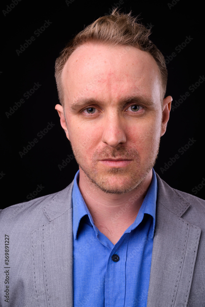 Handsome businessman with blonde hair against black background Handsome businessman with blonde hair against black background