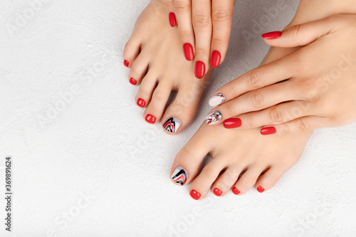 Manicure, pedicure beauty salon concept. Womans hands and feet on gray background.