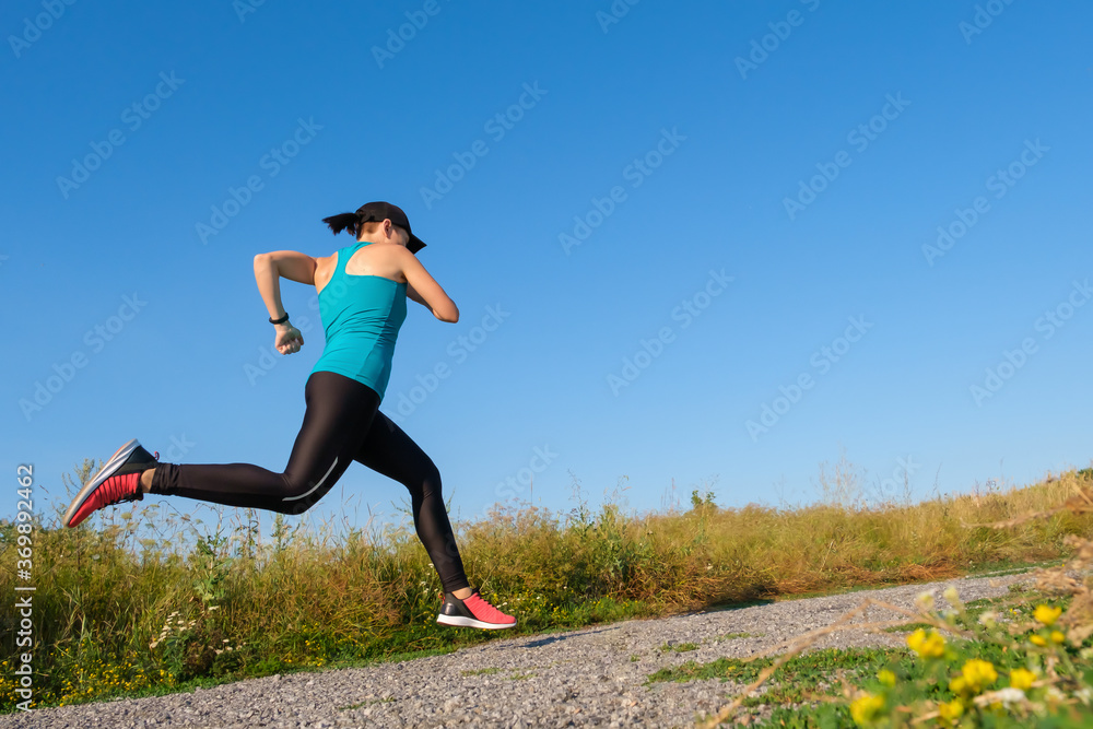 young caucasian fitness woman runs up the country road. young caucasian fitness woman runs up the country road.