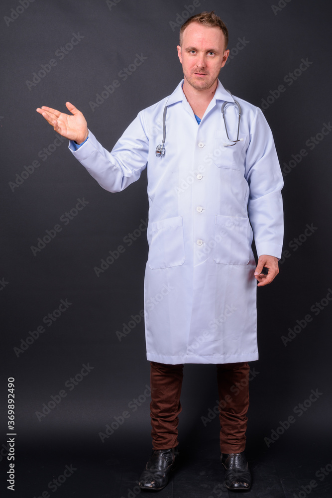 Handsome man doctor with blonde hair against black background Handsome man doctor with blonde hair against black background