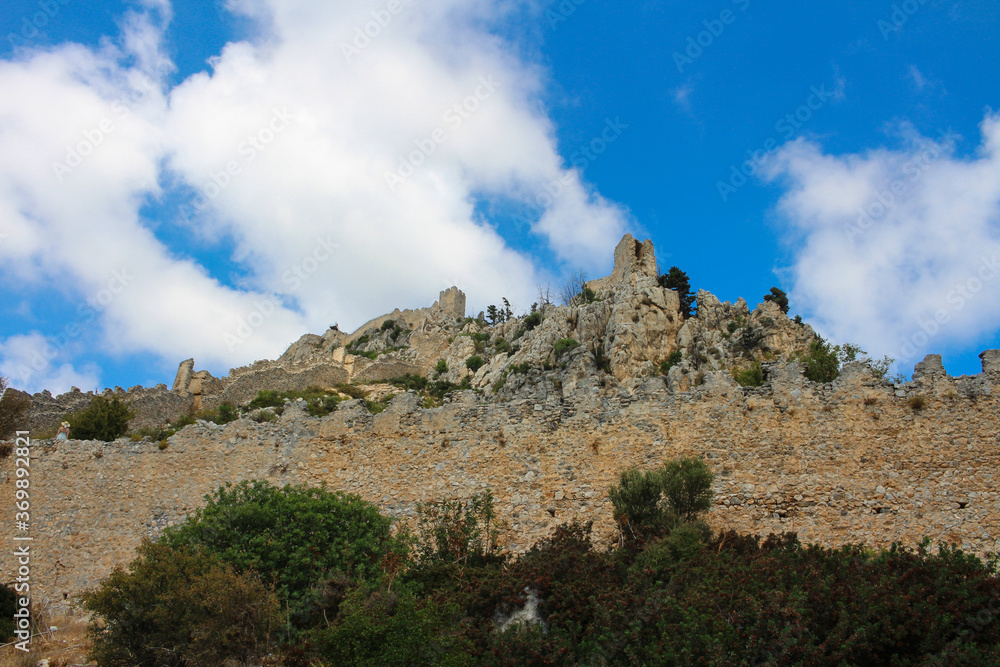 View from the bottom of the three-level castle of Saint Hilarion against a blue sky with clouds. Cyprus.