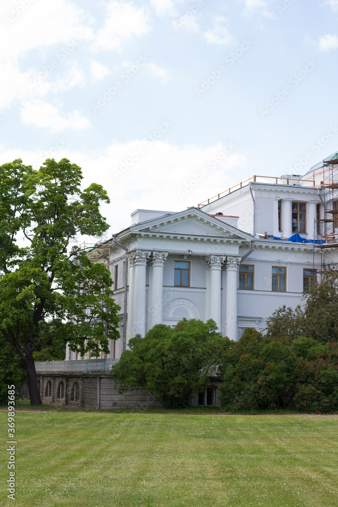 A fragment of the Elaginoostrovsky Palace with white columns, scaffolding and basement arched Windows.