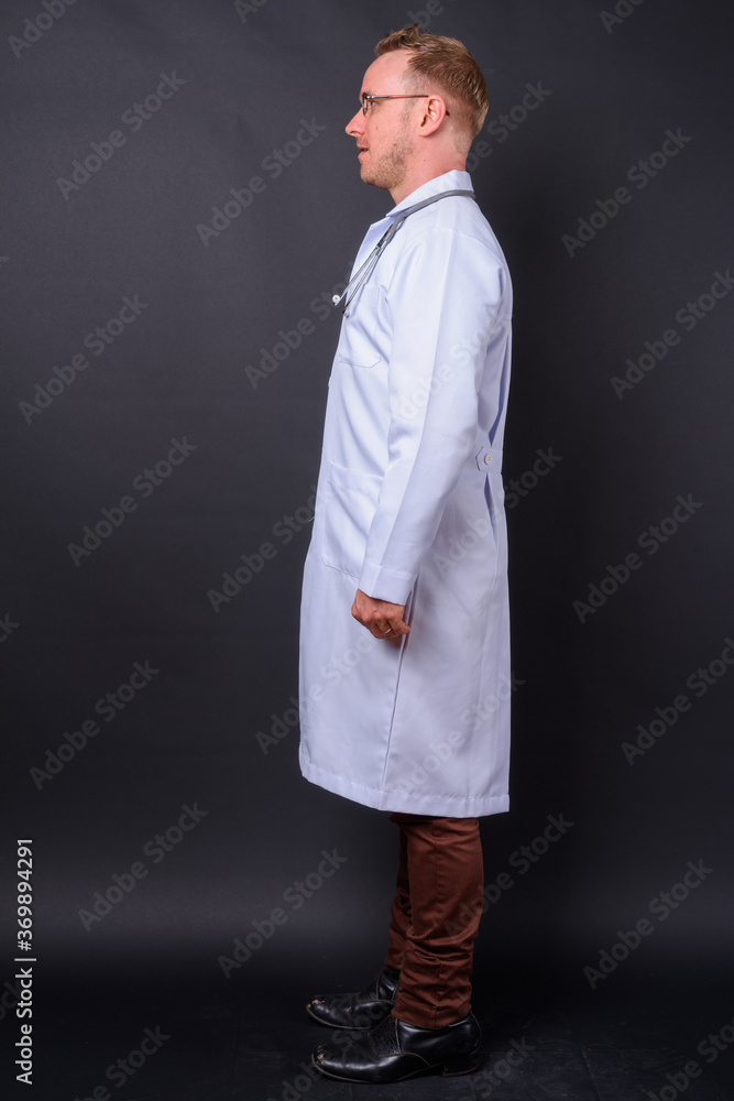 Handsome man doctor with blonde hair against black background Handsome man doctor with blonde hair against black background