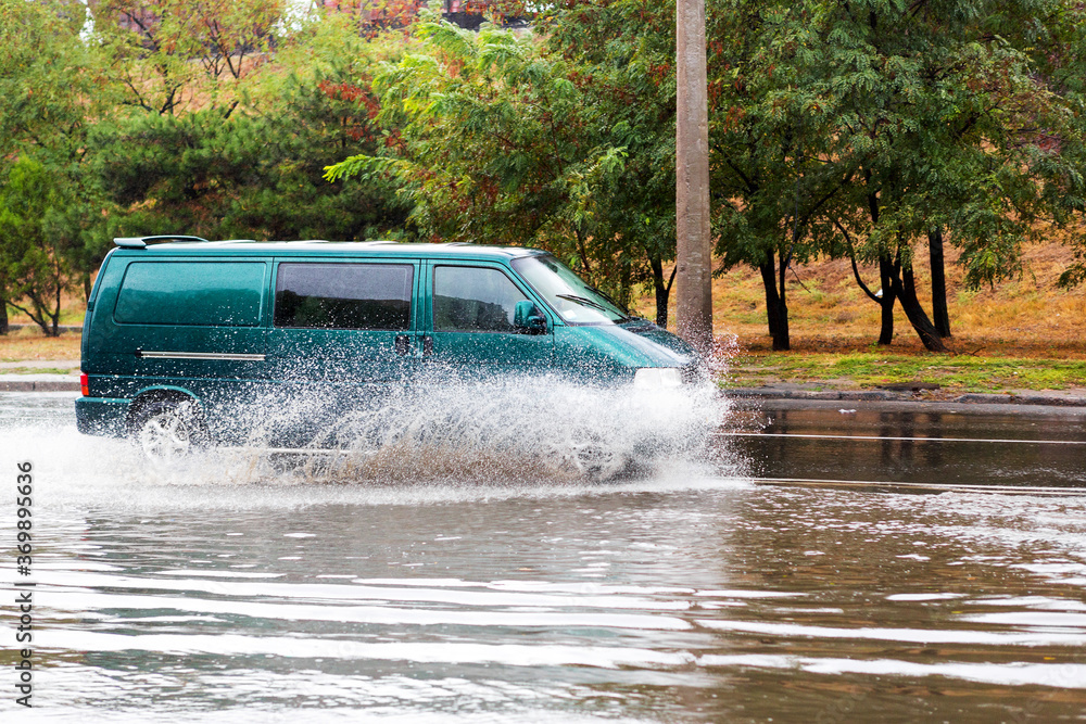 Driving cars on a flooded road during flooding caused by torrential rains. Cars float on water flooded streets. The disaster in Odessa Driving cars on a flooded road during flooding caused by torrential rains. Cars float on water flooded streets. The disaster in Odessa